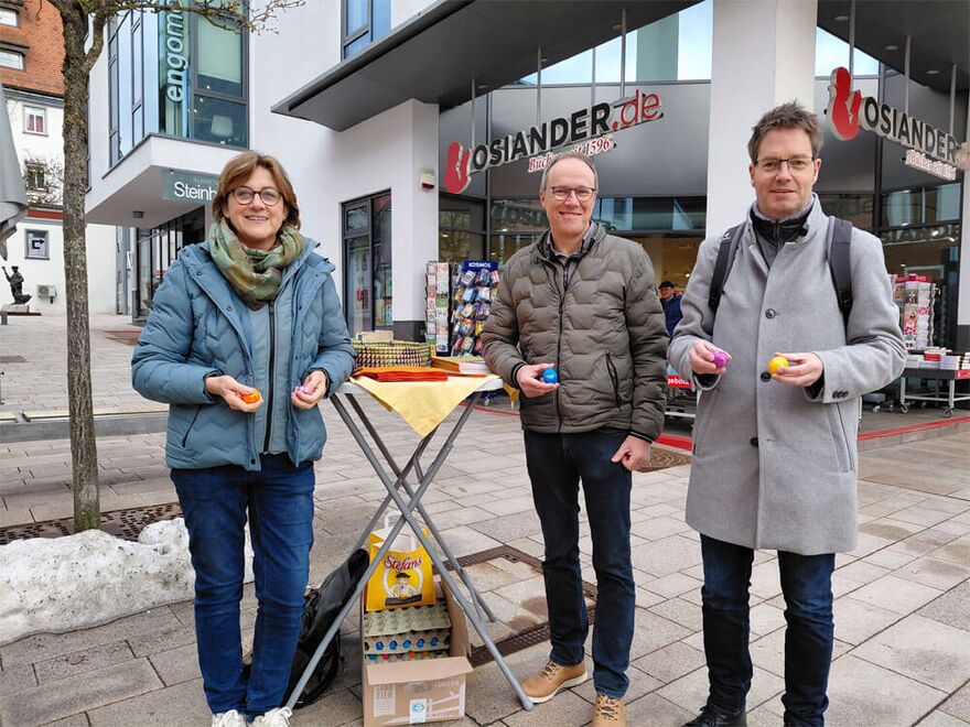 Gravierte Ostereier "Frohe Ostern wünscht ihre Kirche" werden auf dem Wochenmarkt verteilt.